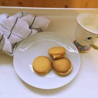Homemade Custard Creams on plate next to a cup of milk