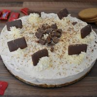 3/4 shot Daim Bar Cheesecake with Daim Bars and biscuits at side