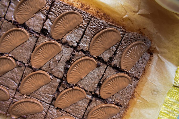 Close shot of chocolate orange brownies flat on baking paper, from above