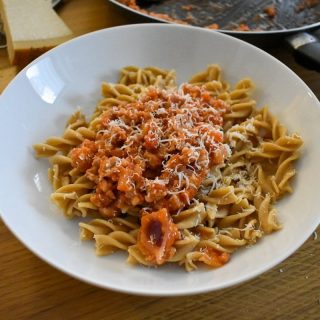 Served sausage pasta with parmesan in bowl