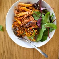 Top shot of served pasta bake with salad in pasta bowl