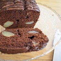 Cut slice of chocolate and pear cake on cake stand