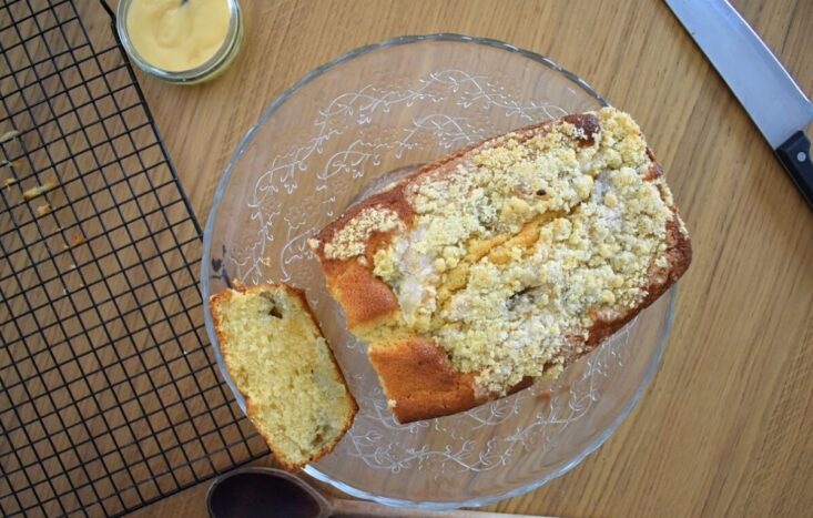 A super moist and fruity treat, this Rhubarb and Custard Cake has gorgeous bursts of tangy rhubarb and sweet custard. All topped with classic crumble for the perfect loaf cake.