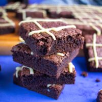 stack of 4 brownies shot in 3/4 angle, bottle and square of brownies blurred in background