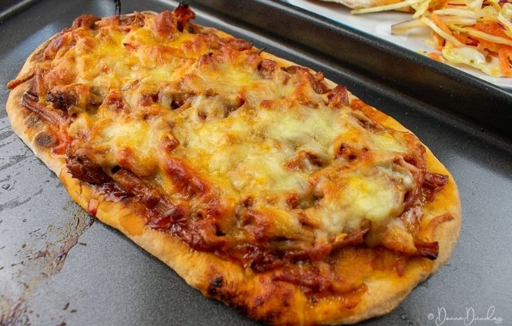 Leftover Roast Pork Flatbread on baking tray. Coleslaw in background.