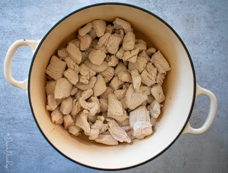 Diced Turkey in cast-iron cooking dish.