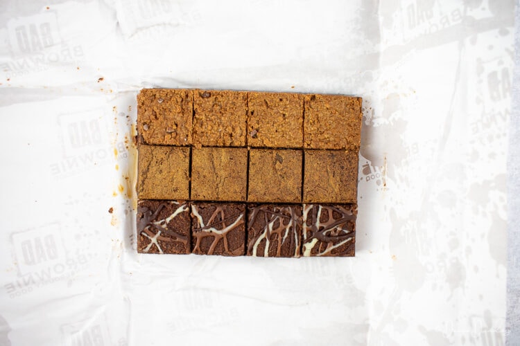 12 brownie squares on white paper.