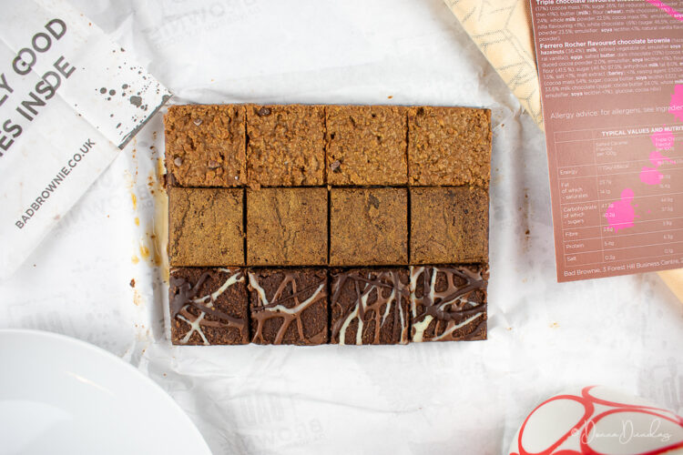 12 squares of brownie on white paper.