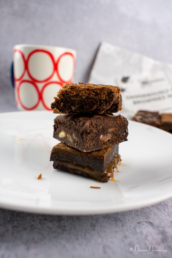 3 Brownies stacked on a plate.