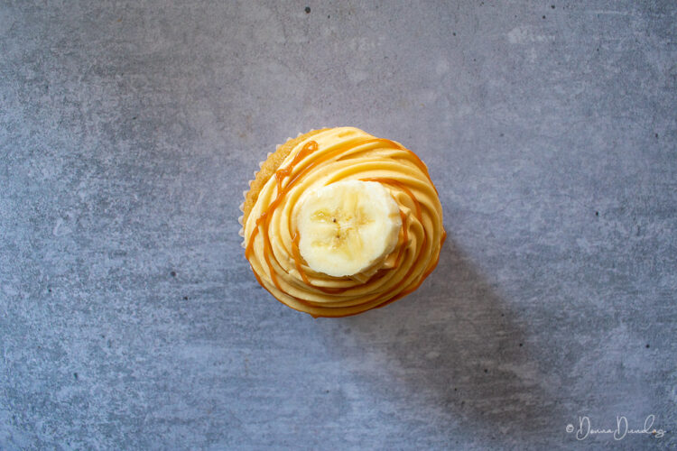 top view of single cupcake topped with banana.