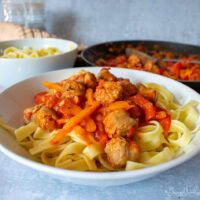 Served sausage pasta, frying pan to the back.