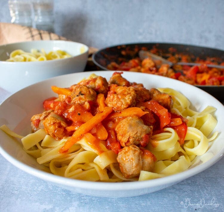 Served sausage pasta, frying pan to the back.
