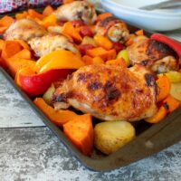 Sweet Chilli Chicken Traybake with serving bowls in the background.