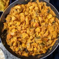 easy chicken curry in the pan, naan bread and rice at top of shot.