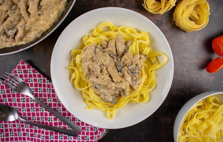 served stroganoff in bowl with pasta.