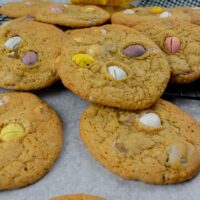 3/4 shot of mini egg cookies on table, tea towel and empty pack in background.