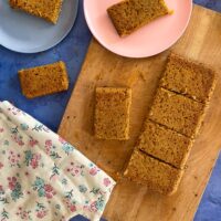 top view of sliced apple flapjacks on chopping board, 2 slice on plates.