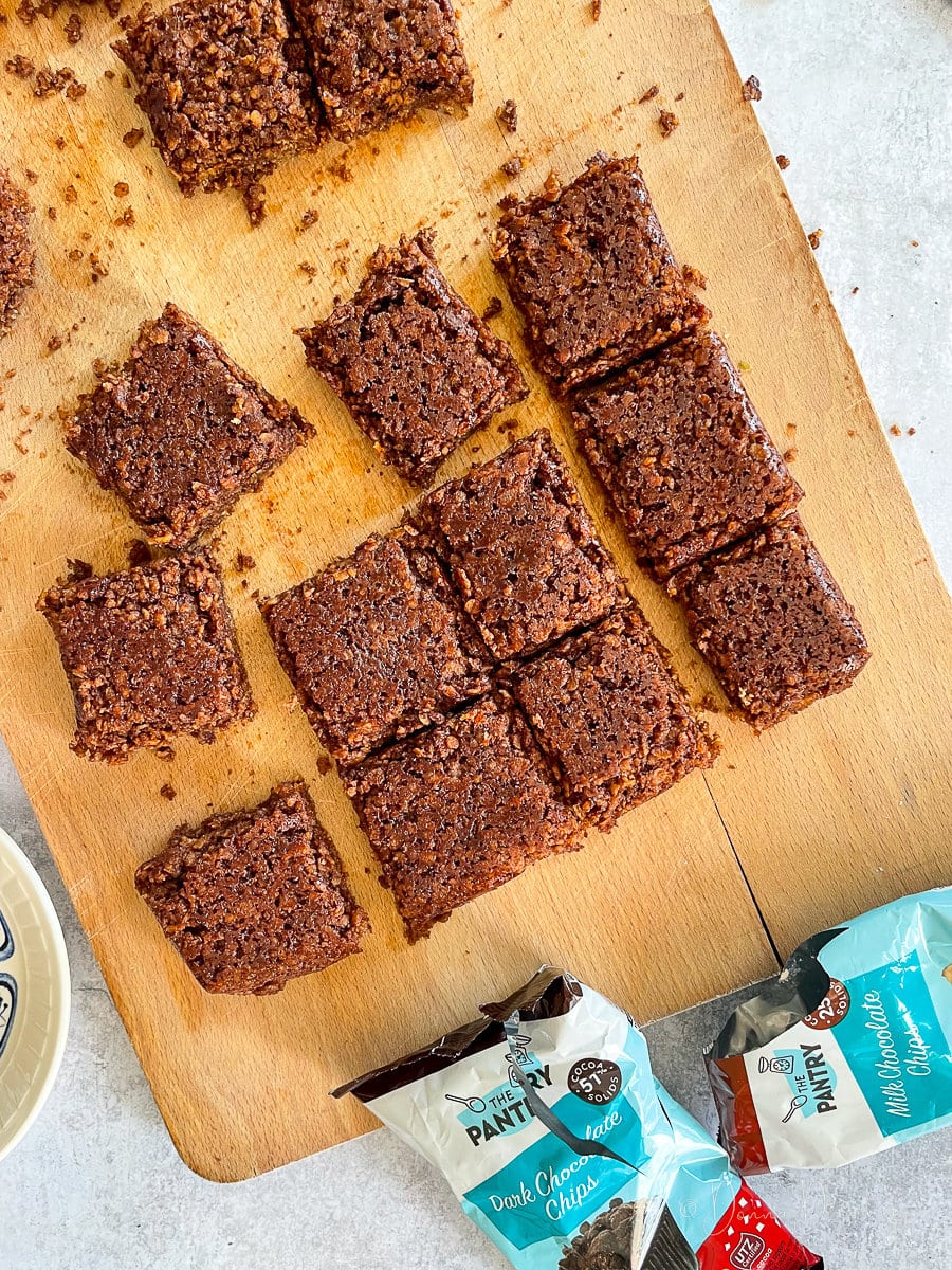 squares of flapjack sliced on wooden chopping board.