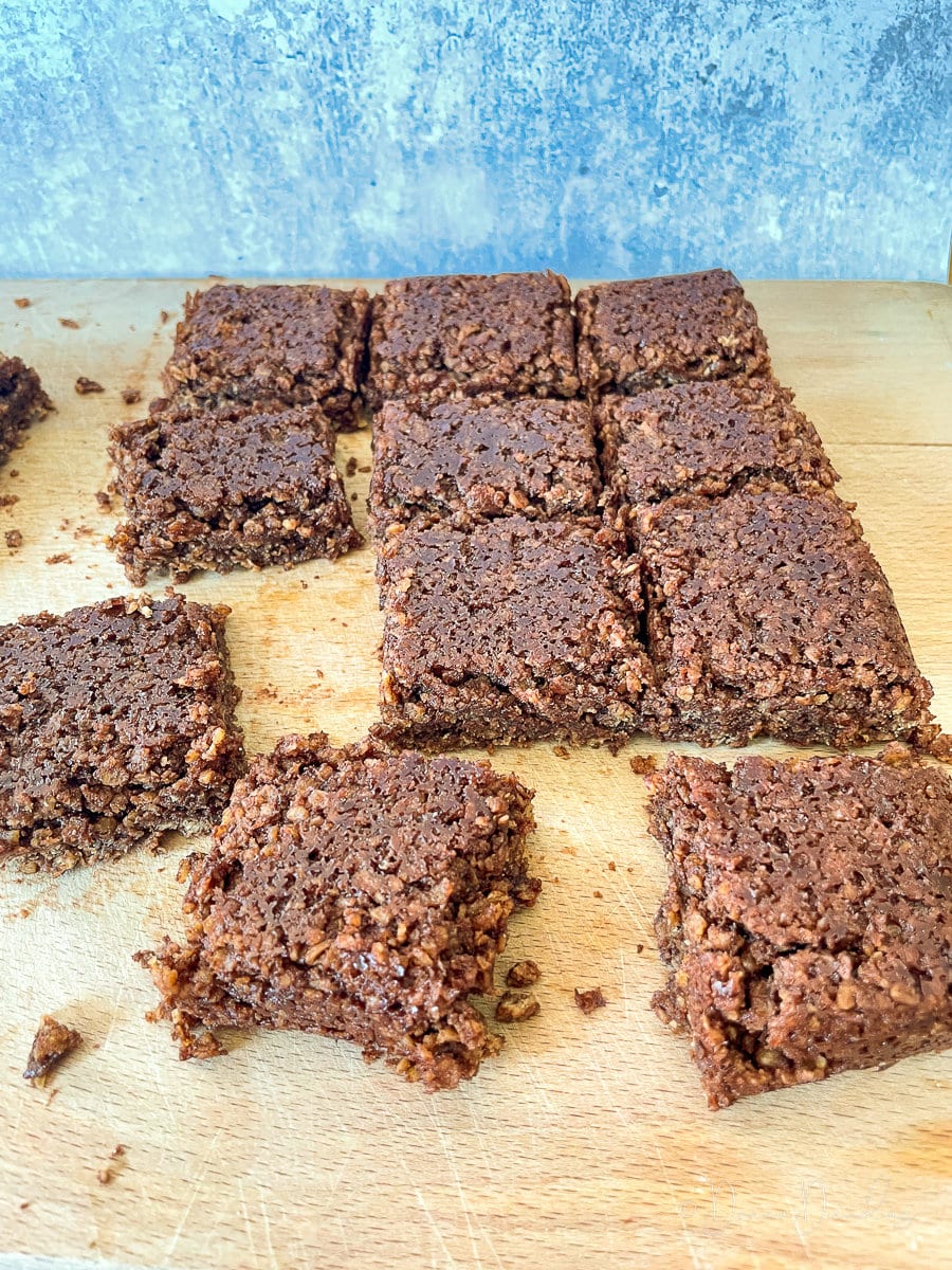 3/4 angle shot of sliced flapjacks on wooden chopping board.