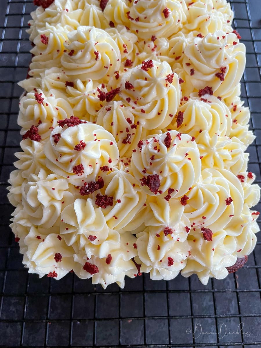 close up of cream cheese icing on wire rack.