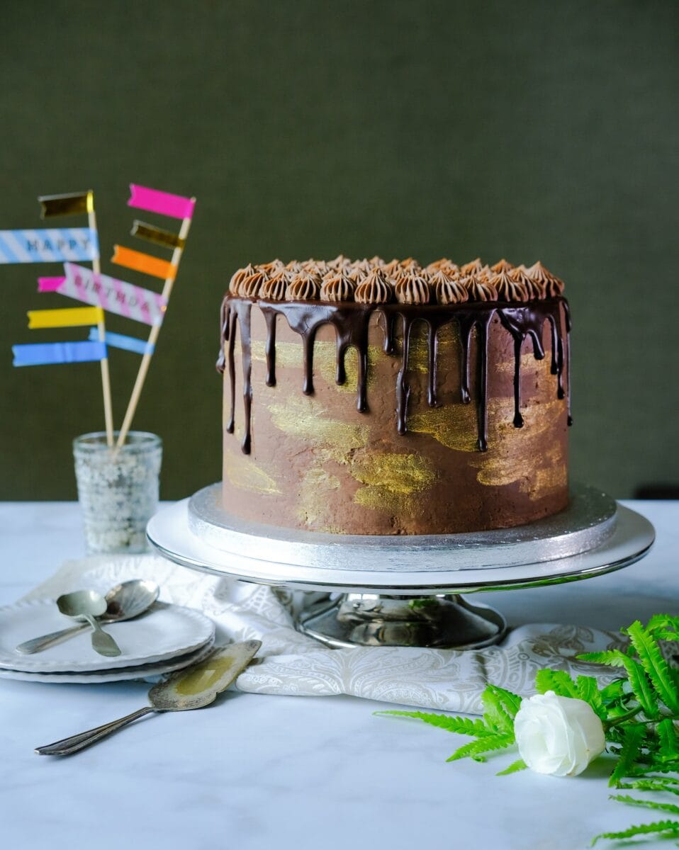 large layer cake with icing and a chocolate drip.
