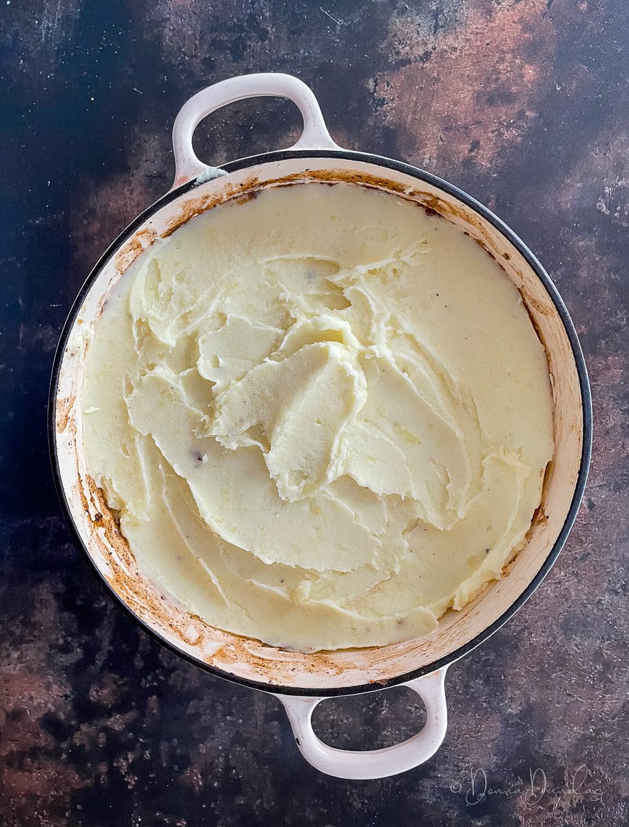 mash potato topped cottage pie in cast iron dish - unbaked.