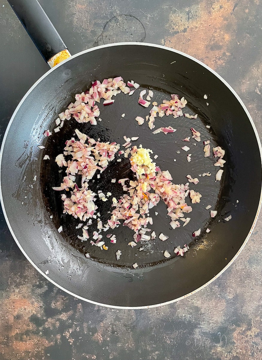 diced red onion and crushed garlic in large frying pan.