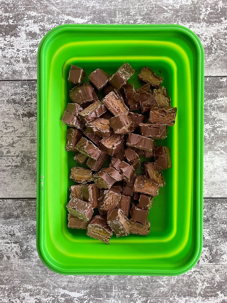 chopped up mars bar pieces in green tub.