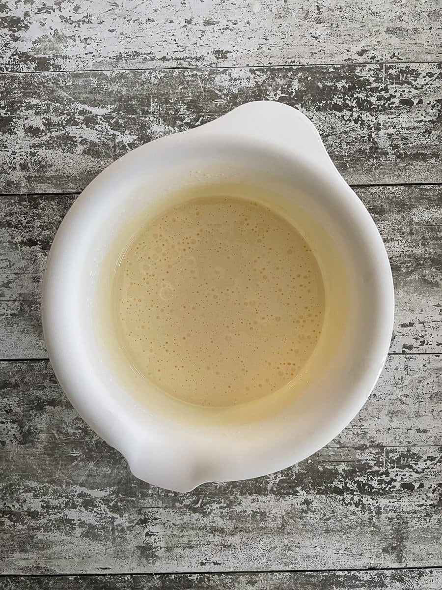 eggs and sugar whisked together in white mixing bowl.