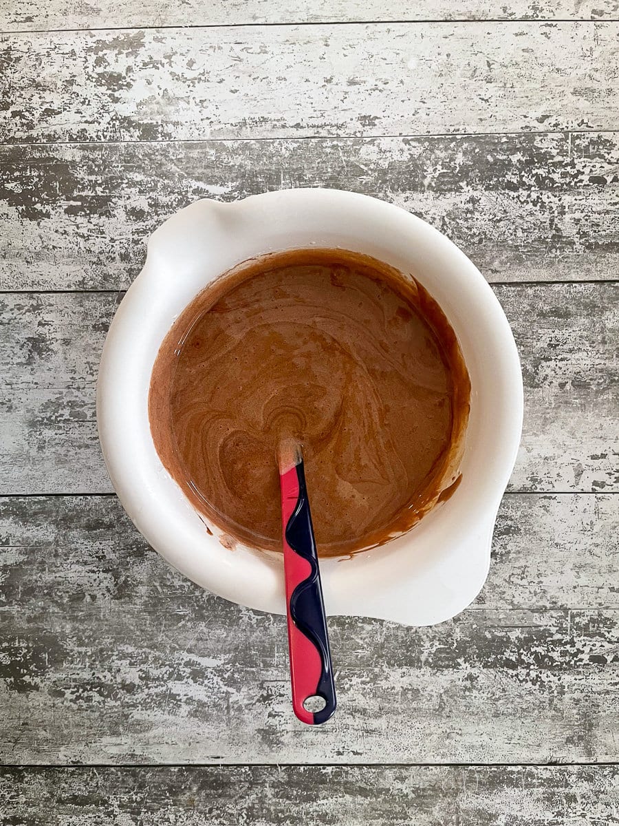eggs, sugar, chocolate and butter mixed together in mixing bowl.