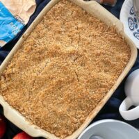 baked crumble in cooking dish. Apples, oats and custard jug also on the table.