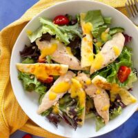 chicken salad topped with mango dressing. Small dish of dressing to the side.