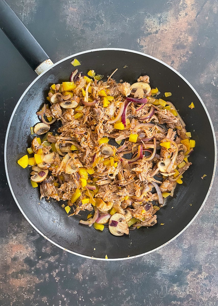pulled pork, mushrooms, peppers in frying pan.