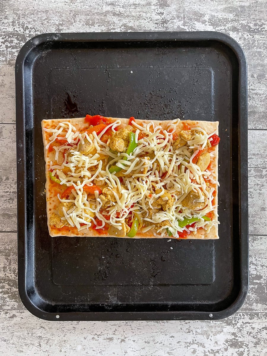 unbaked pizza on baking tray.