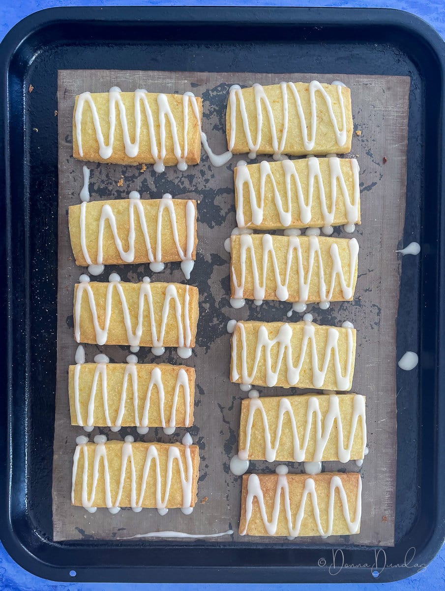 biscuits drizzled in icing on baking tray.