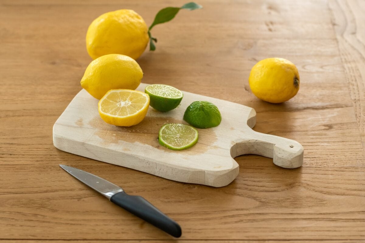 sliced lemons and limes on chopping board.