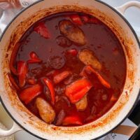 sausage and chorizo casserole in cast iron dish. Bread to the side.