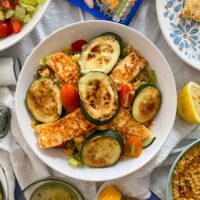 halloumi and couscous salad with courgette in white pasta bowl.