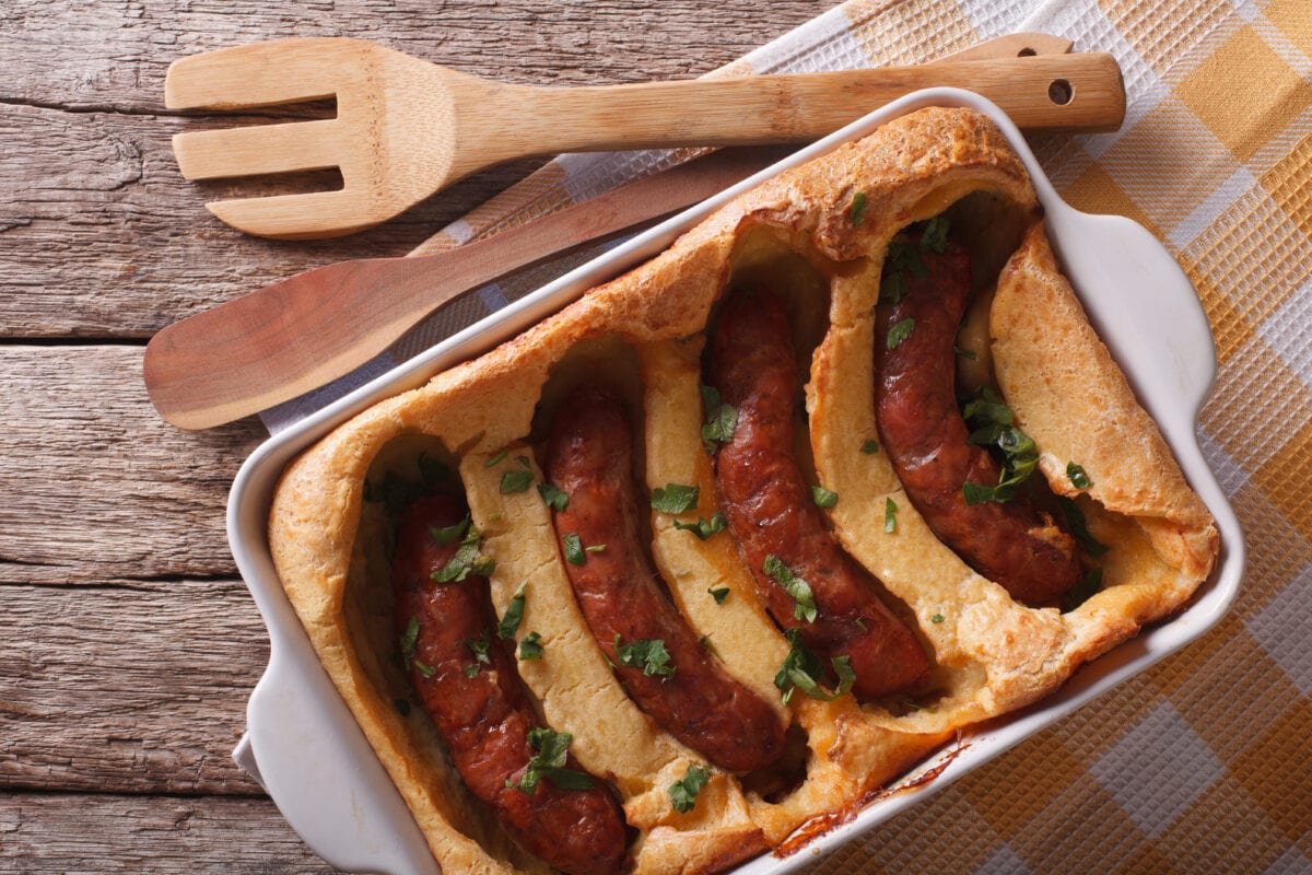 English sausage baked in pastry in a dish close up. Horizontal top view.