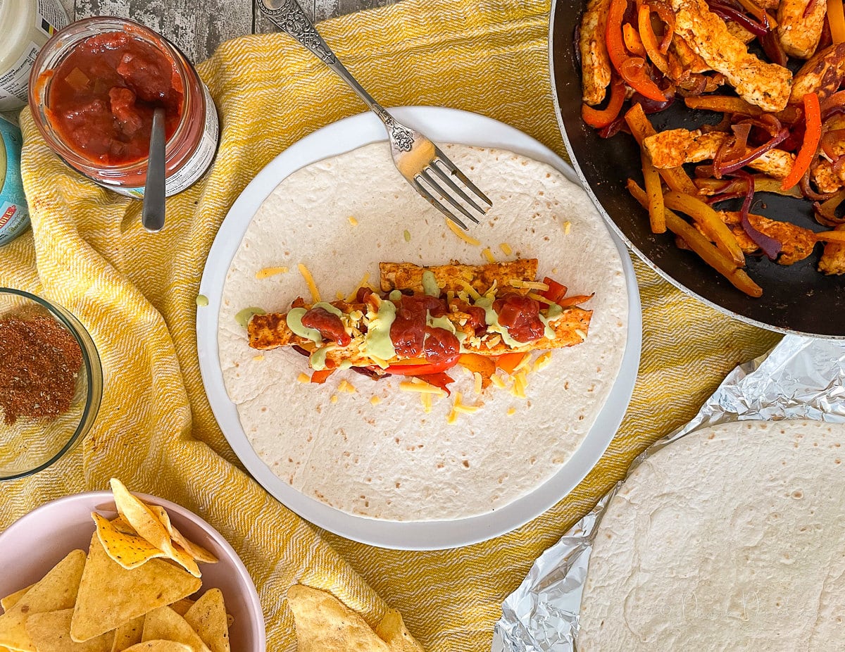 slices of halloumi and peppers on wrap with salas and guacamole.