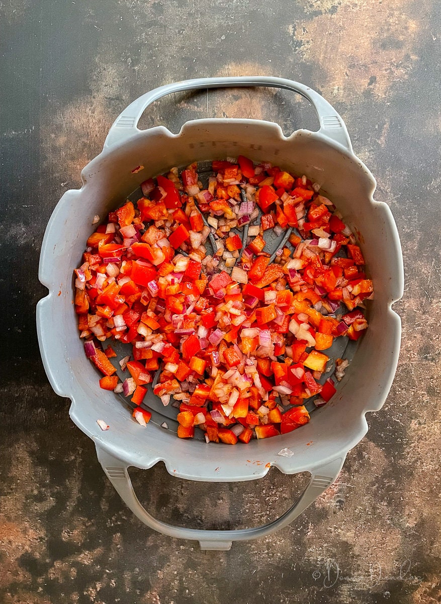 onions and red pepper diced in silicon basket.