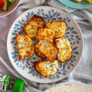 Golden Brown air fryer halloumi cheese on a blue patterned plate.