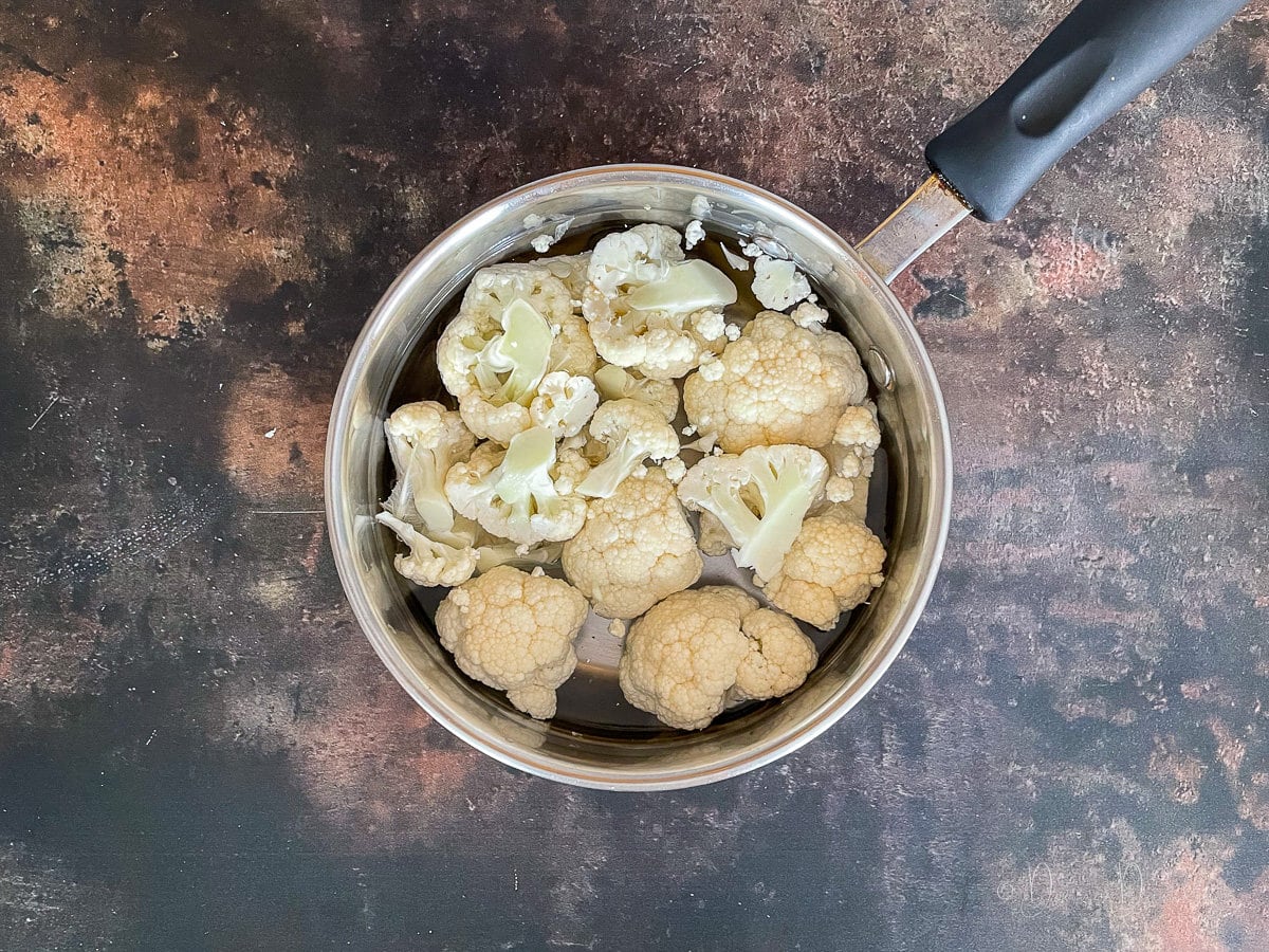 cauliflower florets in pan with water.