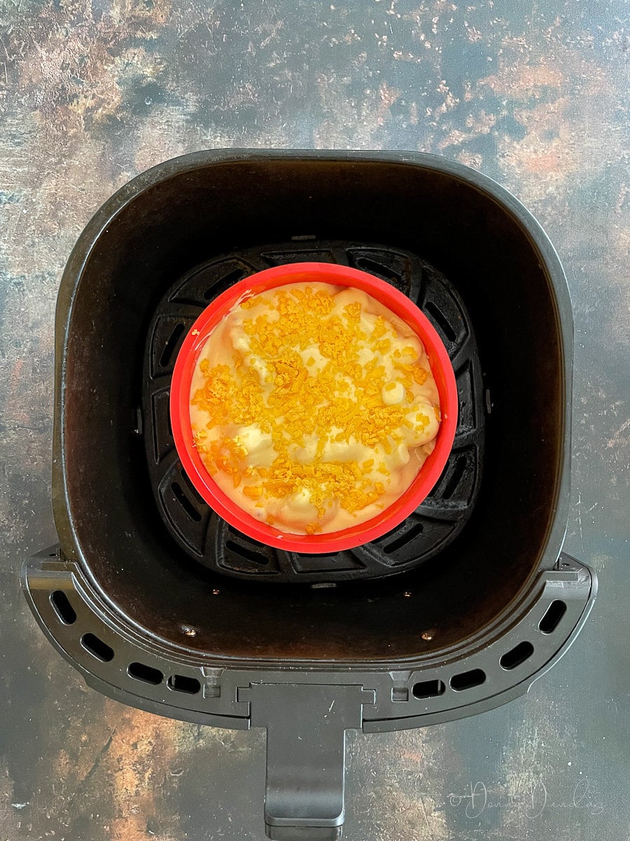 unbaked cauliflower cheese in air fryer basket.