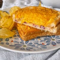 toastie with cheese and onion on plate with crisps.