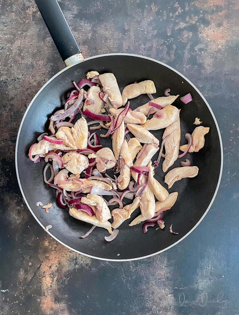 chicken and onions in pan.