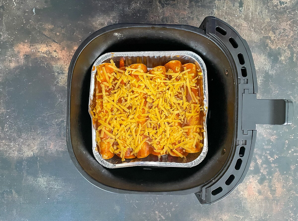 unbaked enchiladas in air fryer basket.