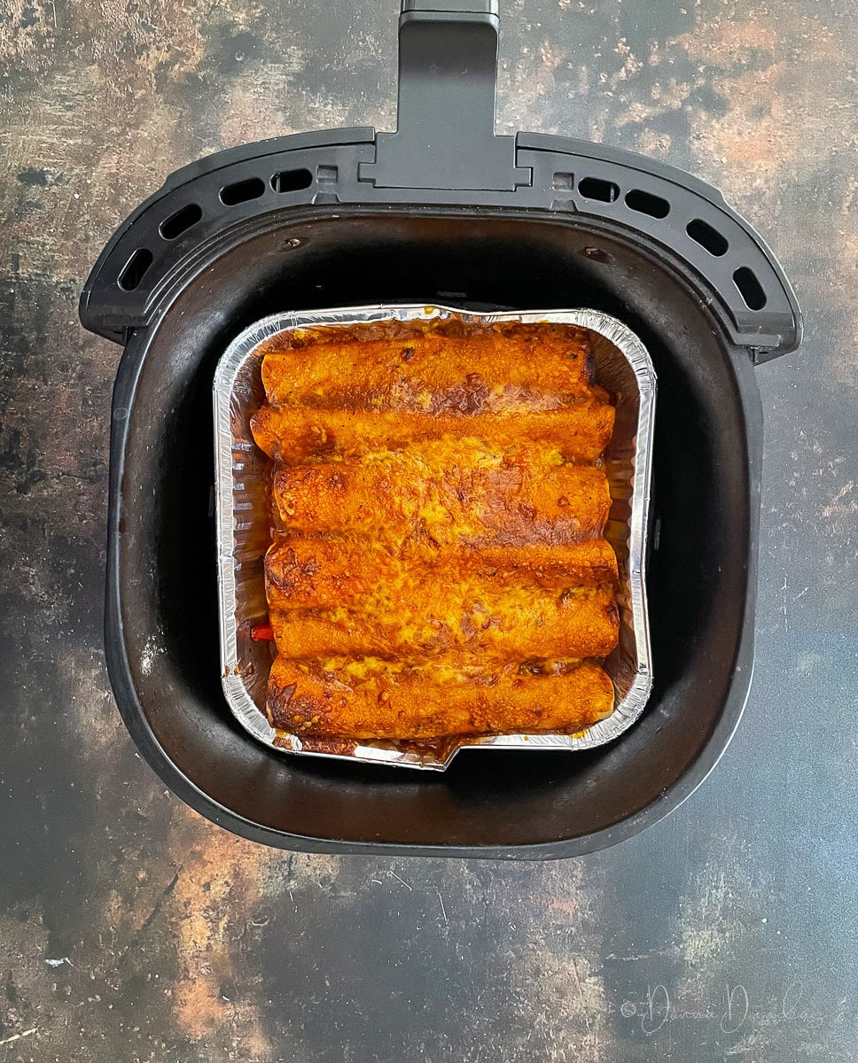 Baked enchiladas in air fryer basket.
