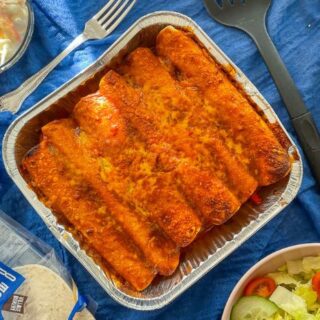 tray of air fryer chicken enchiladas on table with sides.