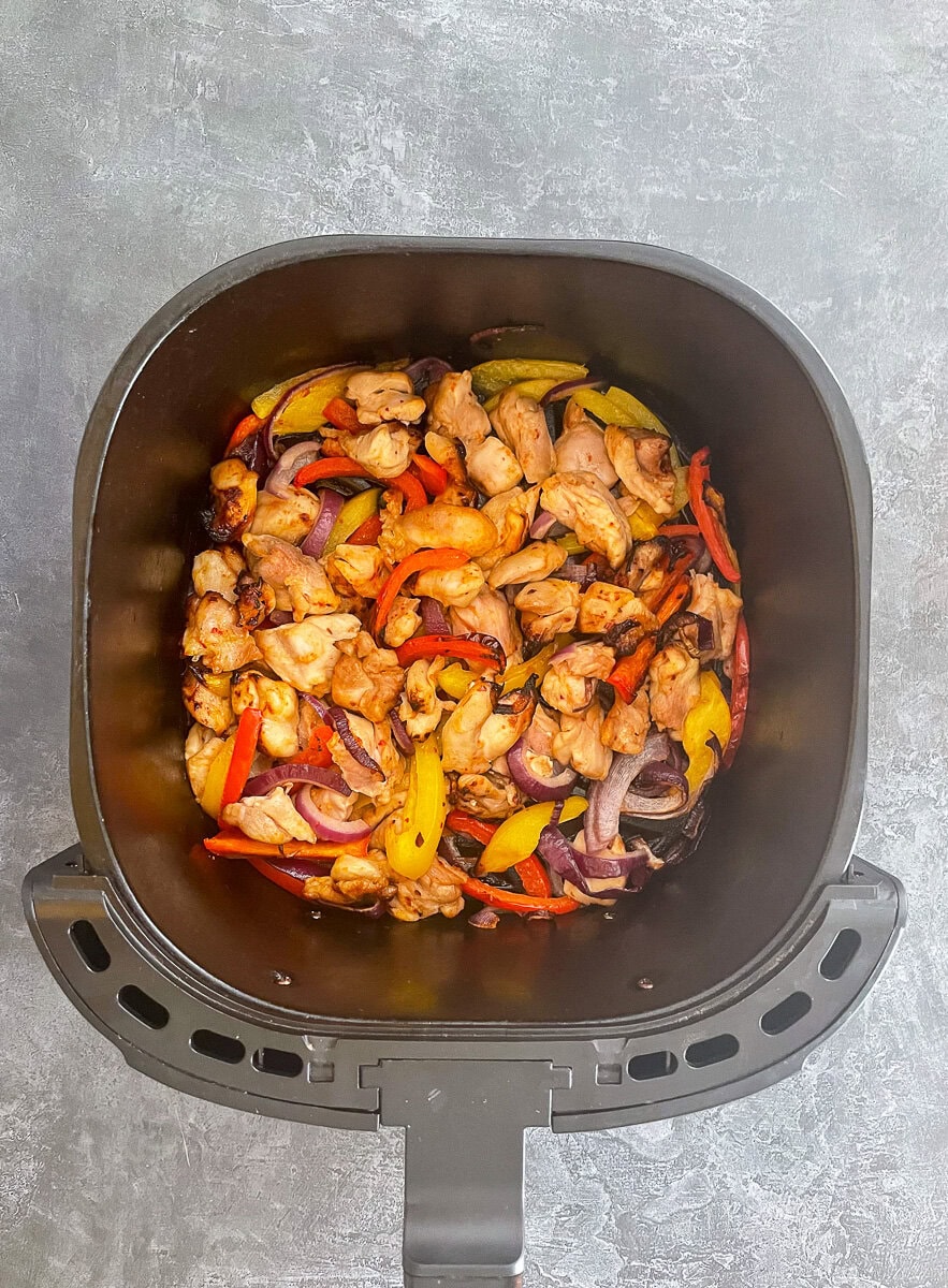 cooked honey chilli chicken in air fryer basket.